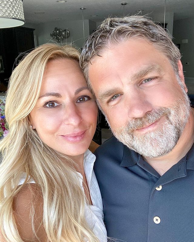 Marc Lukasiak in a blue shirt with his wife in a white tops.